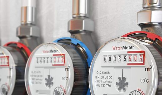 Row of water meters of cold and hot water on a wall.